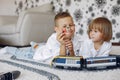 Children playing with lego and toy train in a playing room