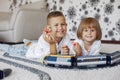 Children playing with lego and toy train in a playing room