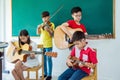 Children playing music instruments in music classroom Royalty Free Stock Photo