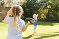 Children playing outside a brother and sister play a ball game in a garden Royalty Free Stock Photo