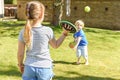 Children playing outside a brother and sister play a ball game in a garden Royalty Free Stock Photo