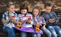Children playing with the phone on bench outdoors