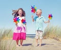 Children Playing Pinwheels by the Coastline Royalty Free Stock Photo