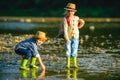 Children playing in the river. Kids in water on river. Warm autumn day. Autumn camp.