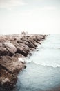 Kids playing on the rocks near the sea