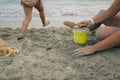 Children playing with sand and bucket in the shore of a sandy beach Royalty Free Stock Photo