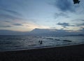 Children playing sea at long quiet beach under beautiful sky Royalty Free Stock Photo