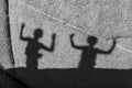 Children playing with shadows on a rock