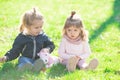 Children playing sitting on green grass in spring park. Children in beautiful spring green field. Brother and sister Royalty Free Stock Photo