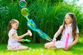 Children playing with soap bubble wand in the park on a sunny summer day Royalty Free Stock Photo