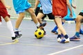 Children playing soccer indoors