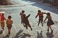 Children playing in the street in the 1960s and 1970s. Chalk drawn games on the road. Neighborhood games Royalty Free Stock Photo