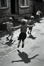 Children playing in the street in the 1940s and 1950s. Chalk drawn games on the road. Neighborhood games Royalty Free Stock Photo