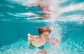 Children playing in swimming pool. Child swim under water in sea. Kid swimming in pool underwater. Happy boy swims in Royalty Free Stock Photo