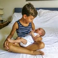 Elder brother holding his newborn brother in his arms Royalty Free Stock Photo