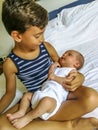 Elder brother holding his newborn brother in his arms Royalty Free Stock Photo
