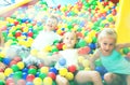 Children playing together in pool with plastic multicolored ball