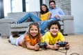 Children playing video games on the carpet in living room Royalty Free Stock Photo