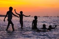 Children playing in the water at sunset Royalty Free Stock Photo