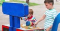 Children playing whack a mole arcade game at an amusement park.