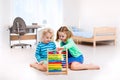 Kids playing with wooden abacus. Educational toy. Royalty Free Stock Photo