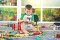 Children playing with wooden train. Toddler boy play with train and cars. Educational toys for preschool and kindergarten child. Royalty Free Stock Photo