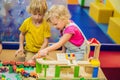 Children playing with wooden train. Toddler kid and baby play with blocks, trains and cars. Educational toys for Royalty Free Stock Photo