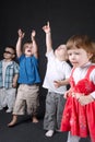 Children pointing up on dark background Royalty Free Stock Photo