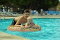 Children at pool, happiness and joy. Two brothers having fun swimming ring Royalty Free Stock Photo