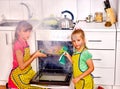 Children poorly cooking chicken at kitchen.