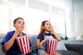 Children, popcorn and television on home sofa for movie entertainment as siblings, subscription or eating. Boy, girl and