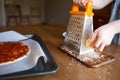 Children prepare pizza at home. girl rubs cheese on a grater