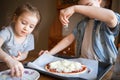 Children prepare pizza at home. Fun activity with kids. Child cook food on kitchen. Sprinkles cheese