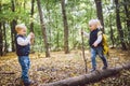 Children preschoolers Caucasian brother and sister take pictures of each other on mobile phone camera in forest park