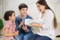 Children presenting a gift to mother Royalty Free Stock Photo