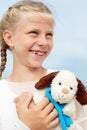 Children psychology. The little beautiful girl embraces an amusing dog - toy. Favorite soft toy.