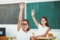 Children raised hands in class room