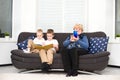 Children read a book, and grandmother plays on a mobile phone.A social problem Royalty Free Stock Photo