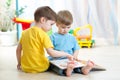 Children read a book sitting on floor at home