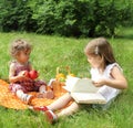 Children reading the book on picnic Royalty Free Stock Photo