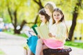 Children reading books at park. Girls sitting against trees and lake outdoor Royalty Free Stock Photo