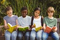 Children reading books at park