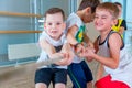 Children and recreation, group of happy multiethnic school kids playing tug-of-war with rope in gym Royalty Free Stock Photo