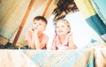 Children relax on camp. Happy family loving children brother and sister play in dark tent in nature. Royalty Free Stock Photo