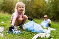 children remove plastic garbage and put it in a biodegradable garbage bag in the open air. The concept of ecology, waste