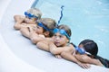 Children resting, hanging on side of swimming pool Royalty Free Stock Photo