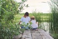 Children resting near the water on sunny summer day, back view Royalty Free Stock Photo