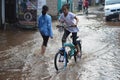 children ride bicycle in the flood after rain