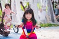 Children ride bicycles in the playground. Cute Asian child sweet smile, wearing colorful dress. Sibling play together for fun. Royalty Free Stock Photo