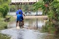 Children ride a bike through flood